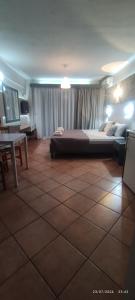 a large bedroom with a large bed and a table at olivegrove in Sidari