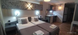 a hotel room with a bed with two towels on it at olivegrove in Sidari