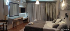 a bedroom with a bed with a desk and a mirror at olivegrove in Sidari