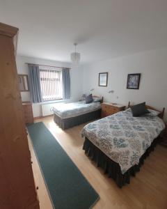 ein Schlafzimmer mit zwei Betten und einem Teppich in der Unterkunft Drumgart Self Catering Cottage in Carrickfergus