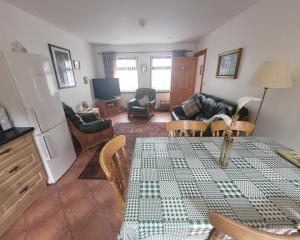 ein Wohnzimmer mit Tisch und Couch in der Unterkunft Drumgart Self Catering Cottage in Carrickfergus