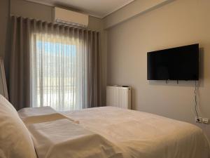 a bedroom with a bed and a television on the wall at Adagio, JIMA winery luxury apartments in Ioannina