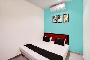 ein Schlafzimmer mit einem Bett und einer blauen Wand in der Unterkunft HOTEL O S S STAY INN in Nagpur