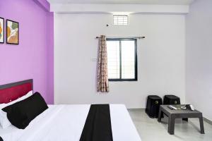 ein Schlafzimmer mit lila und weißen Wänden und einem Bett in der Unterkunft HOTEL O S S STAY INN in Nagpur