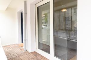 a glass door leading into a room with a wooden floor at Appartement cosy 45 m2 avec terrasse in Gentilly +14 photos