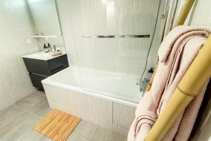 a bathroom with a shower with a tub and a sink at Appartement cosy 45 m2 avec terrasse in Gentilly