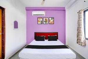 Bett in einem Zimmer mit lila Wänden in der Unterkunft HOTEL O S S STAY INN in Nagpur