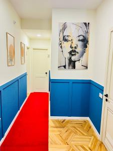 un tappeto rosso in un corridoio con un dipinto sul muro di Pirosmani Boutique Aparthotel a Tbilisi City