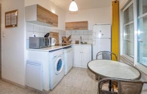 a kitchen with a washing machine and a table at 1 Bedroom Lovely Apartment In Vivario in Vivario