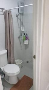 a white bathroom with a toilet and a shower at Skymagz 314 at Cityscape Residences in Bacolod