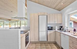 a kitchen with a refrigerator and a sink at Nice Home In Væggerløse With Sauna in Marielyst +19 photos