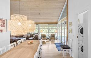 a living room with a chandelier and a dining room at Nice Home In Væggerløse With Sauna in Marielyst