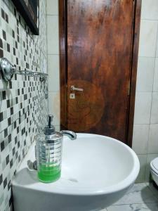 a bathroom with a sink with a green bottle on it at Casa de Buda Chapadmalal in Chapadmalal +6 photos