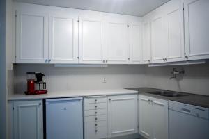 a white kitchen with white cabinets and a sink at Townhouse mitt i centrala Malmö in Malmö +11 photos