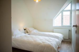 two beds in a white room with a window at Townhouse mitt i centrala Malmö in Malmö