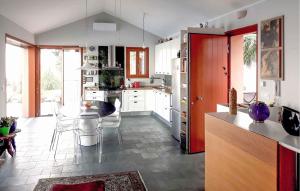 Una cocina con gabinetes blancos y una mesa y sillas. en Villa Mirvami Lovran, en Opatija