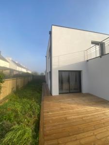 a house with a wooden deck in front of it at Hébergement proche IMT atlantique ifremer thales le dellec in Plouzané