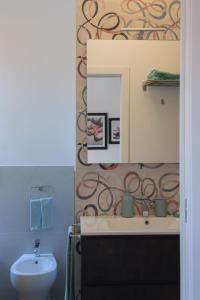 a bathroom with a sink and a mirror at Vikos Lodge Apartment in Bologna