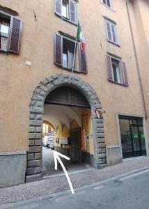 an entrance to a building with an arch with a flag at Cozy Casa Bianca Bergamo in Alzano Lombardo