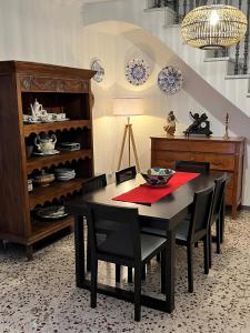 a dining room with a black table and chairs at Casa Rural Oropesa in Villanueva del Ariscal