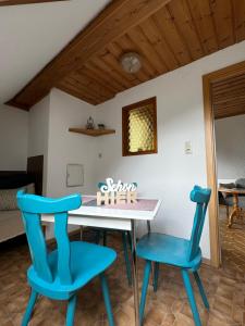 a dining room with blue chairs and a table with a cake at Haus Mali in Heiligenberg