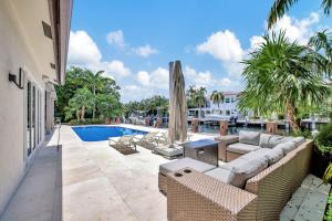 un patio exterior con sofás y una piscina en Elegant Waterfront Estate 6BR- 6.5BA, en Fort Lauderdale