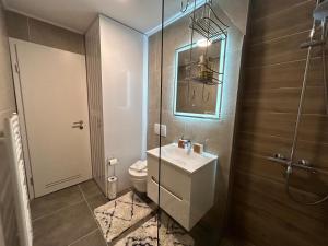 a bathroom with a sink and a toilet and a mirror at Apartman VAND in Tuzla +5 photos