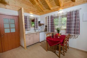 a kitchen with a table with a red table cloth at The Wooden Rose Cabins in Beẕet