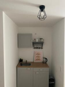 a small kitchen with a sink and a light at 1 Zimmer Studio Apartment in Cologne