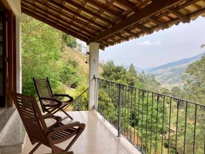 two chairs sitting on a balcony with a view at Chalés de Valfena in São Francisco Xavier