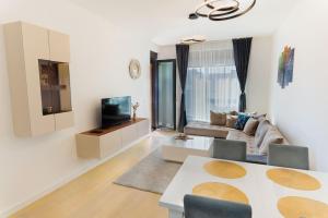 a living room with a couch and a tv at Harizma apartmani - Maja in Kragujevac