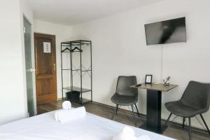 ein Schlafzimmer mit zwei Stühlen, einem Tisch und einem Bett in der Unterkunft Hotel Marina in Aachen