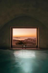 a room with a window looking out at the sunset at Aethra Vegan Caves in Pirgos