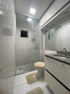 a bathroom with a shower and a toilet and a sink at Apartamento completo no Guarujá in Guarujá