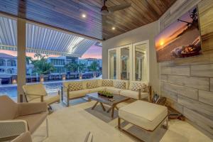 Una sala de estar con un sofá y un televisor en una pared. en Elegant Waterfront Estate 6BR- 6.5BA, en Fort Lauderdale