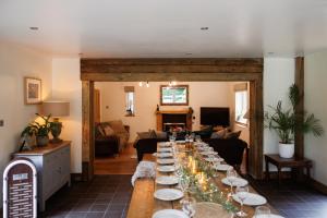 a living room with a long table with wine glasses at Cheerful 7-bedroom house with hot tub sleeps 25 in Iron Acton