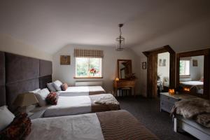 a hotel room with two beds and a mirror at Cheerful 7-bedroom house with hot tub sleeps 25 in Iron Acton