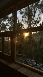 a view of the sunset from a window of a house at Refugio Ecológico Hanan Pacha Granja, Montañas y Aventura in Huaraz