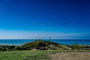 a hill with a lighthouse on top of it next to the ocean at B&B L'EDEN DI CAPO BIANCO in Montallegro