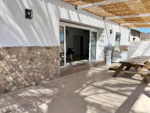 a patio with a picnic table and a stone wall at Casa de la Abuela, a estrenar! escapada Rural in Mazarrón
