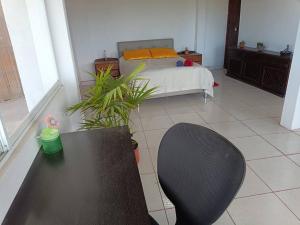 a room with a bed and a table and a chair at Nebraska's Corner cerca de aeropuerto de Tababela in Yaruguí