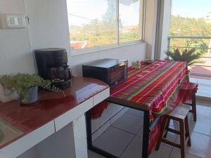 eine Küche mit einer Theke mit einem Tisch mit einer Mikrowelle in der Unterkunft Nebraska's Corner cerca de aeropuerto de Tababela in Yaruguí