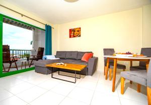 a living room with a couch and a table at 1 bedroom for 4 people with pool Puerto de la Cruz in Puerto de la Cruz