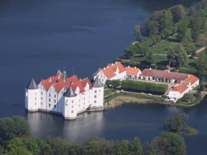 a large castle on an island in the water at Hotel-Restaurant Faehr-Cafe in Niesgrau