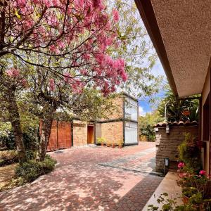 Un edificio de ladrillo con un árbol con flores rosas. en Casa Lloret, en Cuenca 35 fotos más