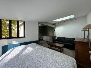 ein Schlafzimmer mit Bett und ein Wohnzimmer in der Unterkunft Petite maison indépendante avec parking in Vétheuil