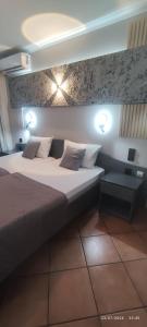 a bedroom with a bed with lights on the wall at olivegrove in Sidari