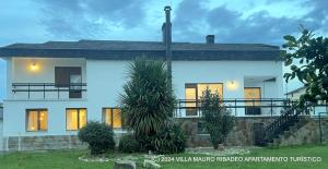 Biały dom z włączonymi światłami w obiekcie Villa Mauro Ribadeo Apartamento Turístico w mieście Ribadeo