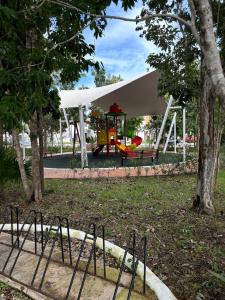 a park with a playground with a tent and a swing at In Wotoch in Cancún