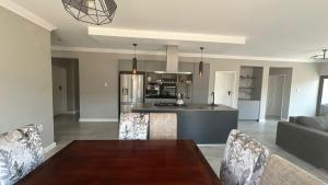 a dining room and kitchen with a table and chairs at CELONIA VILLA - Euphoria Golf Estate in Naboomspruit